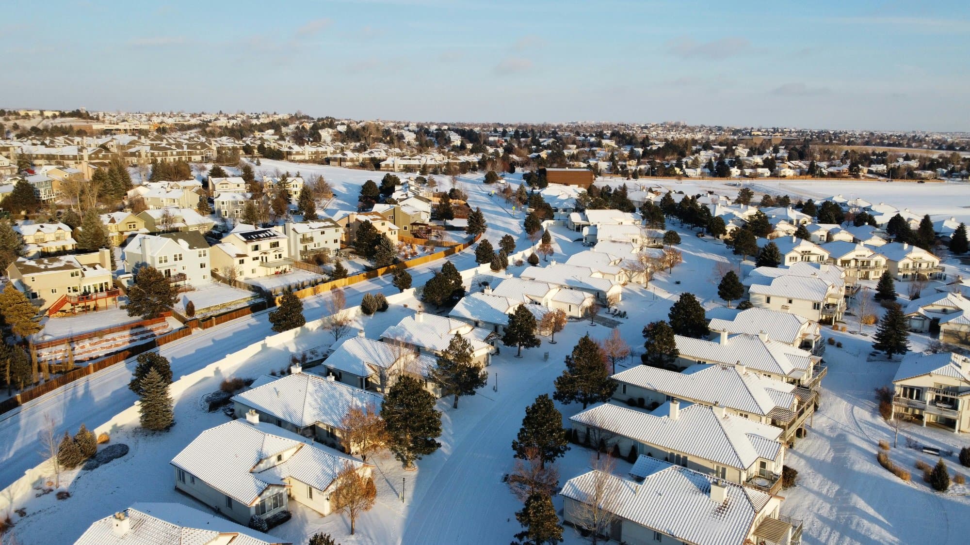 Snow-covered Colorado Springs neighborhood seen from the air at sunrise
