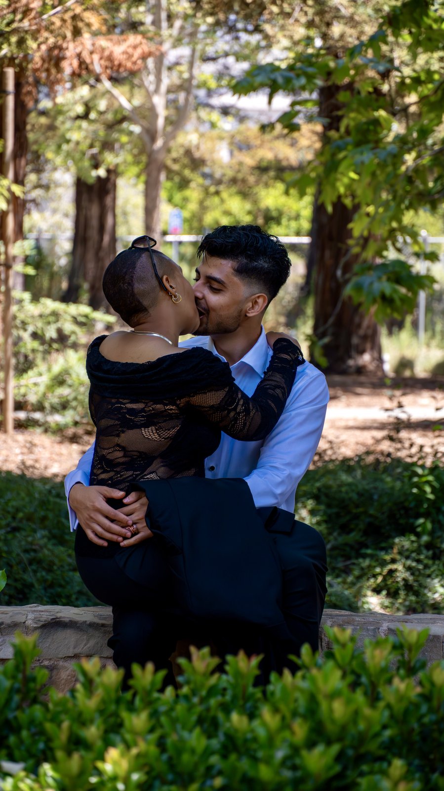 An engaged couple photographed outdoors at golden hour